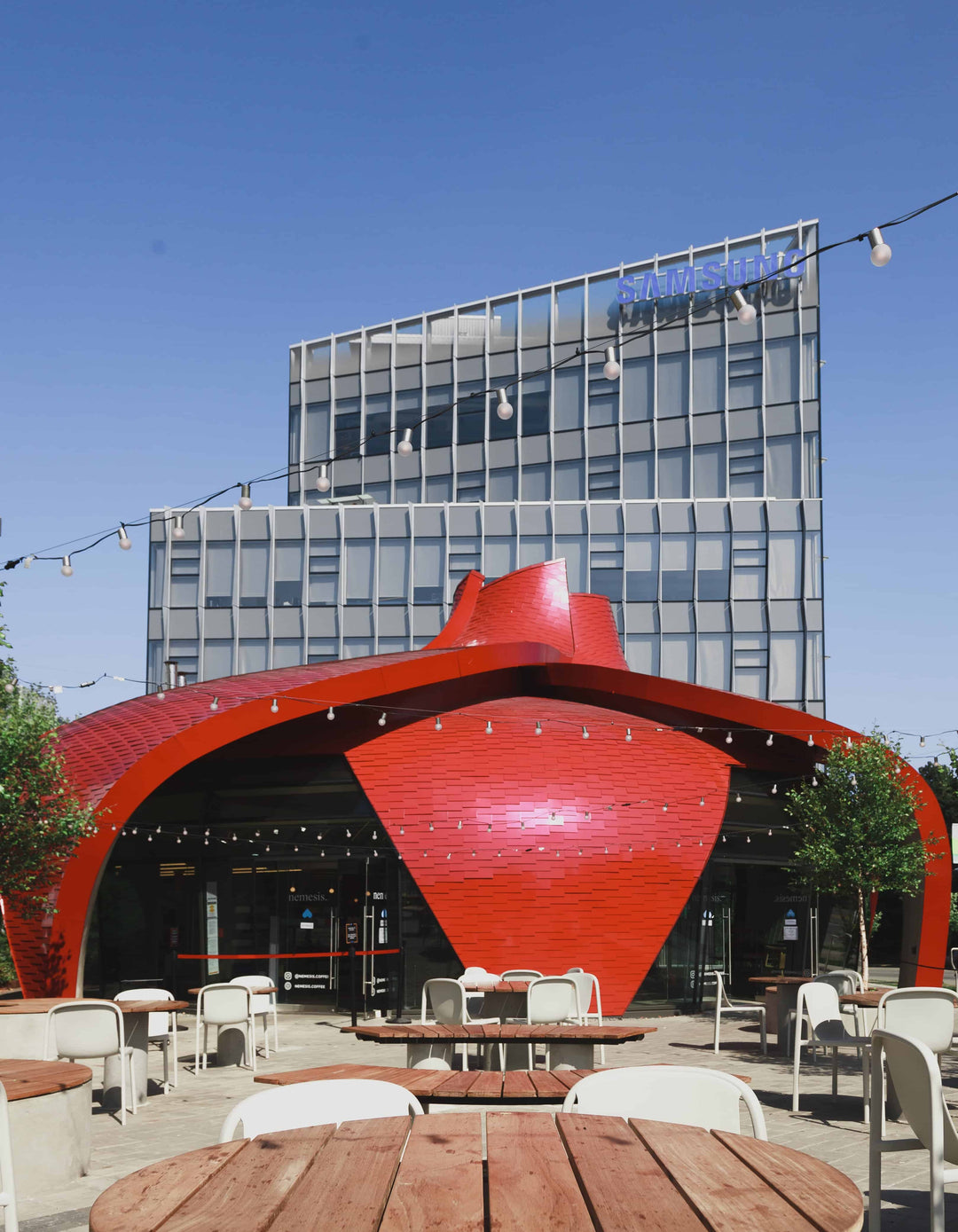 GNW Nemesis Coffee Shop Location red building with blue sky and a larger building in the background